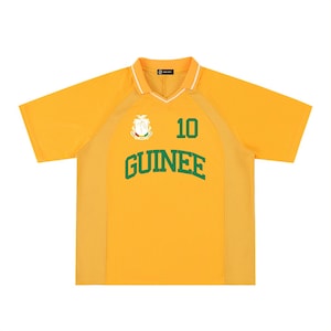 May include: A yellow short-sleeved jersey with a white collar and green detailing. The word "GUINEE" is printed in green block letters across the chest, with the number "10" above it. A crest is on the left chest.
