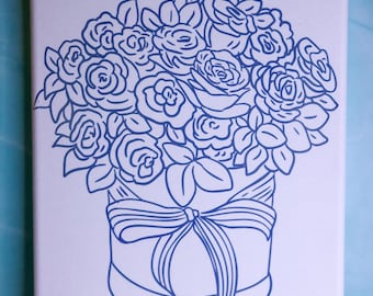 May include: A canvas art print featuring a blue line drawing of a bouquet of roses in a round box tied with a bow. The artwork is set against a white background.
