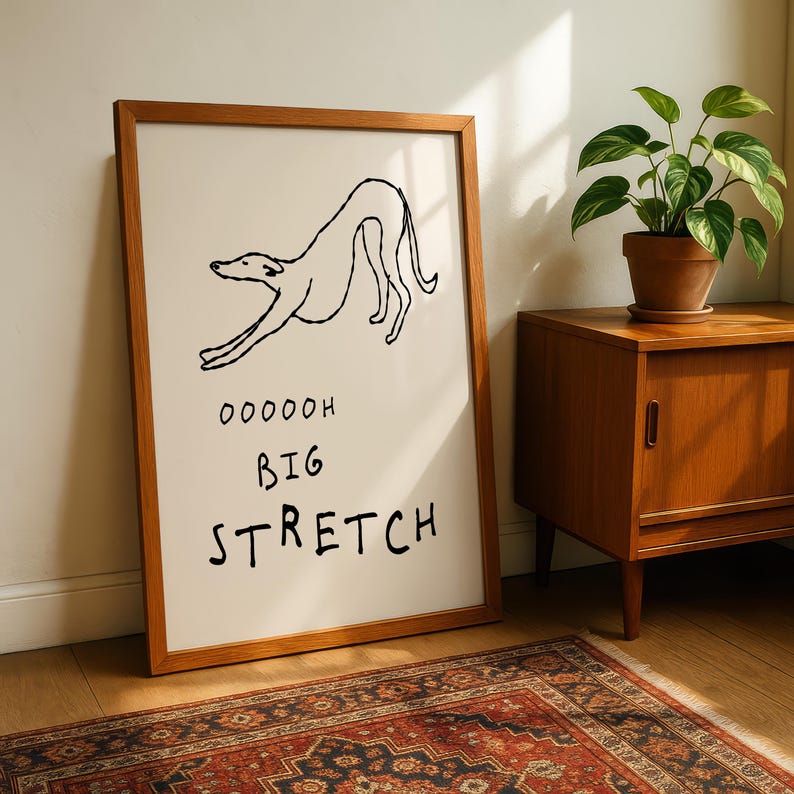 a framed drawing of a dog in a playful pose, accompanied by the text "OOOOH BIG STRETCH" in a humorous and exaggerated manner.