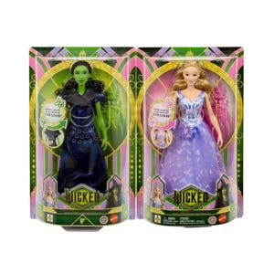 May include: Two boxed dolls from the musical "Wicked". One doll has green skin and wears a dark blue dress. The other doll has blonde hair and wears a purple dress. The boxes have the word "Wicked" and the phrase "Sing-a-Senta, For Good".