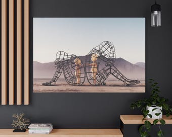 Puede incluir: Impresión en lienzo que presenta una escultura surrealista de dos figuras en un paisaje desértico. Las figuras están construidas con una estructura de alambre oscuro, con una forma más clara y dorada en el interior de cada una.