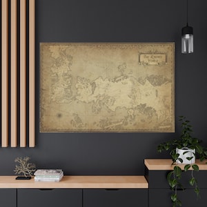 Könnte beinhalten: Eine gerahmte, sepiafarbene Karte der "Bekannten Welt" an einer dunklen Wand. Die Karte zeigt detaillierte geografische Illustrationen und ist wahrscheinlich ein dekoratives Wandkunstwerk.