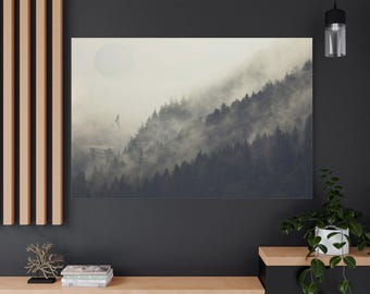 Puede incluir: Una impresión en lienzo que representa una escena montañosa brumosa con un sol grande y pálido. La obra de arte presenta un denso bosque en una ladera, parcialmente oscurecido por la niebla. Un pequeño edificio y un pájaro son visibles.