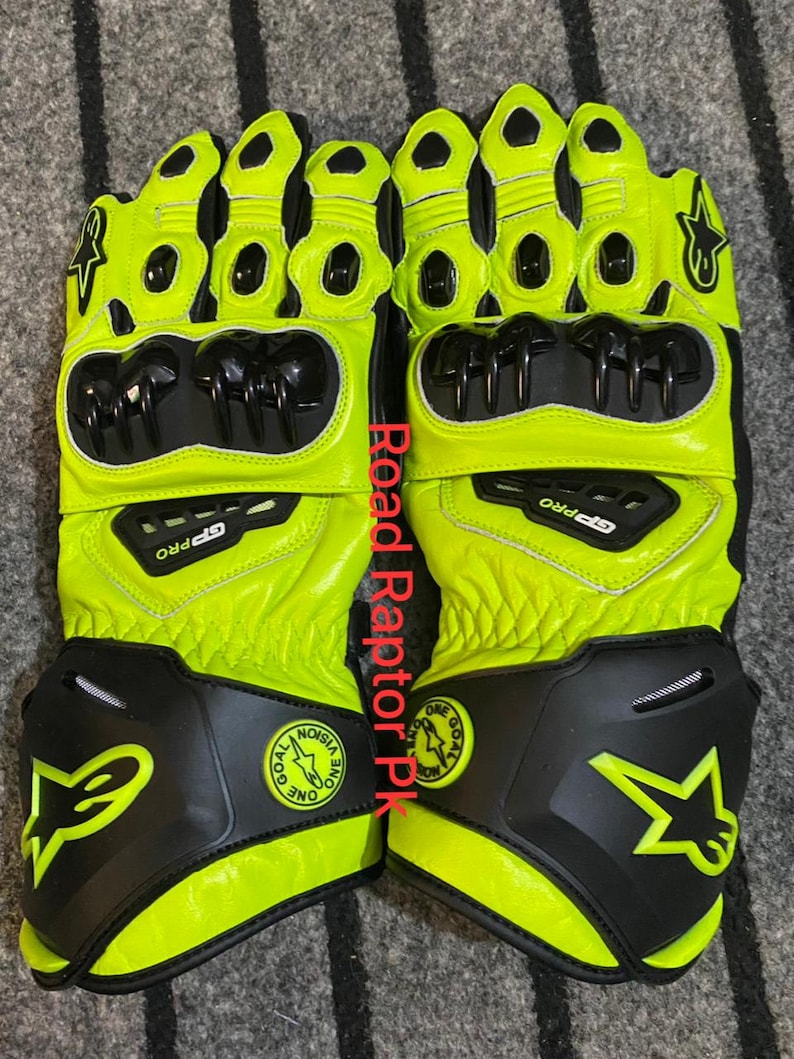 May include: A pair of neon yellow and black motorcycle gloves. The gloves have black protective panels on the knuckles and wrist. The gloves have the text "GP PRO" and a star logo.