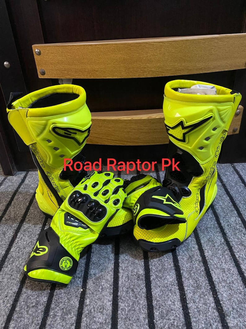May include: Bright yellow and black motorcycle boots and gloves. The boots have a high-top design with black accents and the brand logo. The gloves are also yellow and black, featuring protective padding. The text "Road Raptor Pk" is visible.