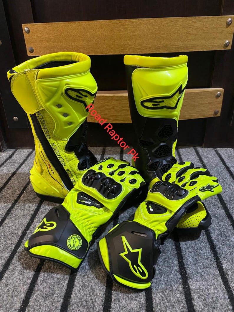 May include: A pair of neon yellow and black motorcycle boots and gloves. The boots are tall, with a prominent yellow shin guard and black accents. The gloves have a similar design, with black knuckle protection and yellow detailing. The text "Road Raptor PK" is visible.
