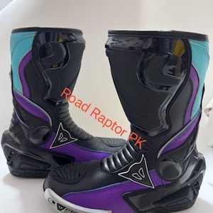 Może przedstawiać: Para czarnych i fioletowych but&oacute;w motocyklowych z turkusowymi i fioletowymi akcentami. Buty mają elegancki design z logo marki z boku i napisem "Road Raptor PK". Buty mają ochronny design.