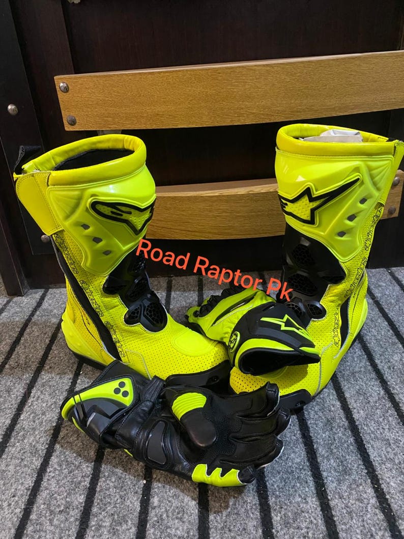May include: A pair of neon yellow and black motorcycle boots and gloves. The boots are high-top with black accents and the gloves are black with neon yellow details. The text "Road Raptor Pk" is visible.