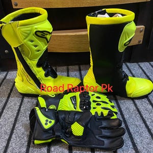 May include: A set of motorcycle gear, including black and neon yellow boots and gloves. The boots are tall, with a black shaft and neon yellow accents. The gloves are black with neon yellow protection. The text "Road Raptor Pk" is visible.