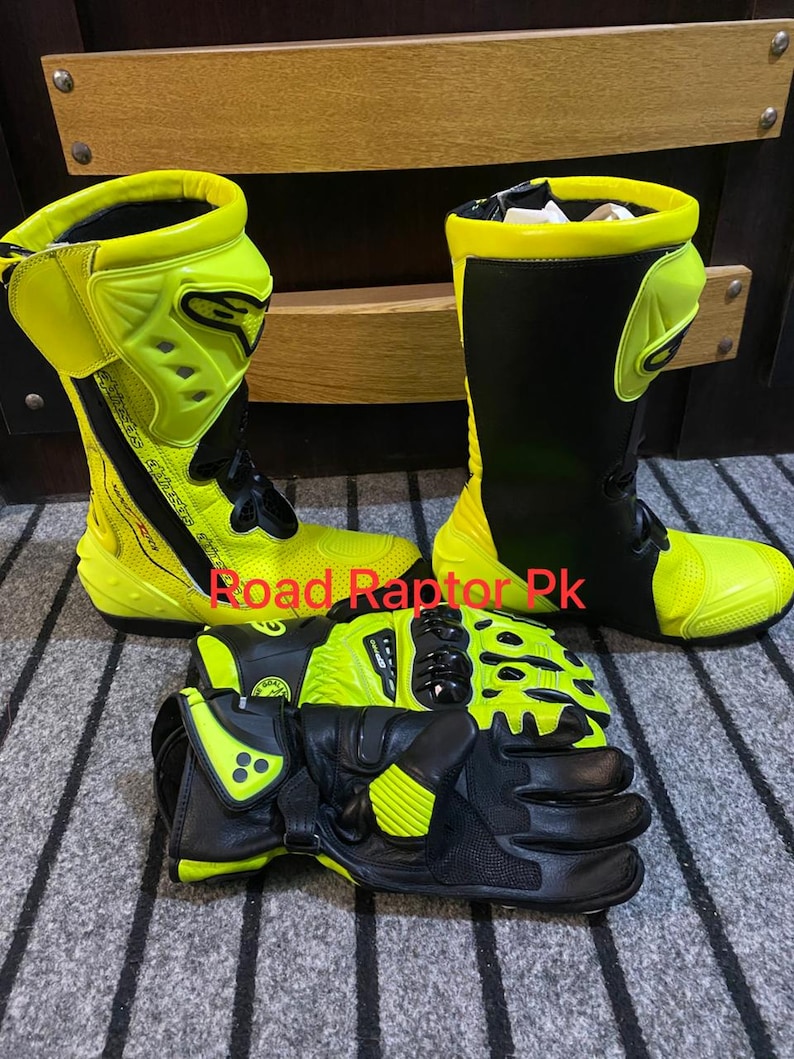 May include: A set of motorcycle gear, including black and neon yellow boots and gloves. The boots are tall, with a black shaft and neon yellow accents. The gloves are black with neon yellow protection. The text "Road Raptor Pk" is visible.
