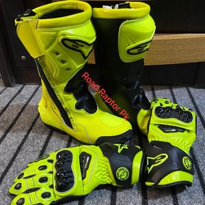 May include: A pair of neon yellow and black motorcycle boots and matching gloves. The boots are high-top with protective features, and the gloves have reinforced knuckles. The text "Road Raptor Pk" is visible on the image.