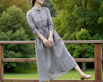Robe longue minimaliste en lin à manches longues, avec un design inspiré du style cottage, une attache réglable dans le dos et une fermeture boutonnée sur le devant.