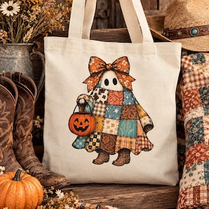 Pode incluir: Uma sacola de lona cor de creme com um gr&aacute;fico de um fantasma vestindo um len&ccedil;ol com padr&atilde;o de patchwork, um grande la&ccedil;o floral laranja e botas de cowboy marrons, segurando um pequeno balde de ab&oacute;bora laranja para doces.
