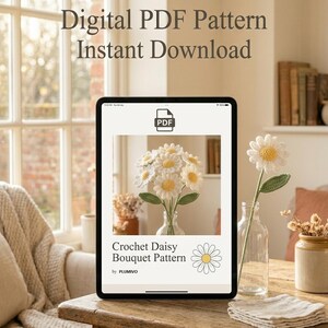 May include: A digital PDF pattern for a crochet daisy bouquet is displayed on a tablet. The tablet is on a wooden table, with a crocheted daisy in a glass vase. The text on the tablet reads "Digital PDF Pattern Instant Download".