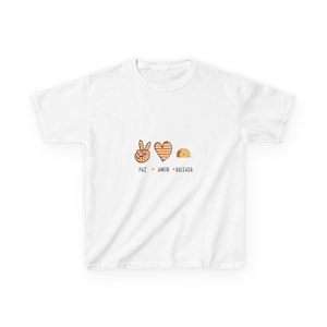 May include: White t-shirt with a graphic design featuring a peace sign, a heart, and a taco. The text below the images reads "PAZ AMOR BALEADA" in orange. The peace sign and heart have orange and white details, and the taco is brown.