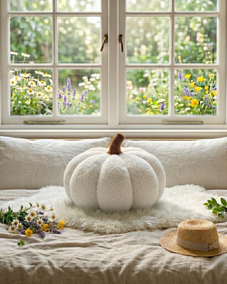 Boucle plush pumpkin pillow collection layout showcasing three available sizes (15cm, 25cm, 35cm). Cozy minimalist autumn aesthetic featuring handmade pumpkin throw pillows with brown stems on a light wood display shelf.