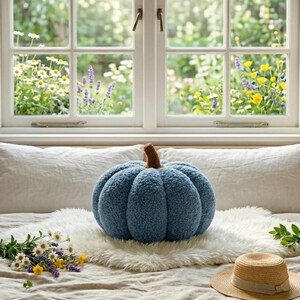 Graphic showing three fall-colored sherpa pumpkin pillows neatly arranged on a wood shelf. Includes descriptive text for buyers comparing sizes: 35cm large yellow pumpkin, 25cm medium white pumpkin, and 15cm small green pumpkin.