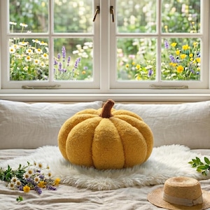 Three trendy boucle pumpkin cushions in sage green, white, and yellow sitting on a shelf. Infographic text highlights the 15cm, 25cm, and 35cm size options for handmade holiday living room decor.