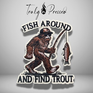 May include: An embroidered patch featuring a brown Bigfoot character wearing a black cap and sunglasses, holding a fishing rod with a caught trout. The text reads "FISH AROUND AND FIND TROUT" in black lettering, with "Truly n Pressed" at the top.