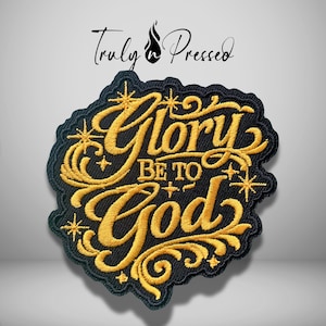 May include: A black embroidered patch featuring the gold-stitched text Glory Be To God in a decorative script font. The design includes gold star accents and swirling flourishes on a black fabric background with a scalloped edge border.