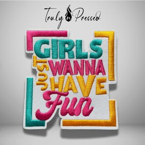May include: A white embroidered patch featuring the text "GIRLS WANNA HAVE FUN" in teal, pink, and yellow thread. The design is framed by geometric corner accents in pink, teal, and yellow. The text "Truly Pressed" appears above the patch.