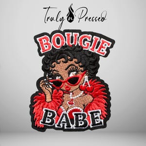 May include: An embroidered patch featuring a cartoon character with black hair, red cat-eye sunglasses, and a red feather boa. The text reads BOUGIE at the top and BABE at the bottom in white letters with black outlines. The brand name Truly n Pressed is above.