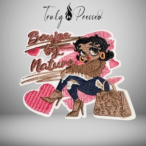 May include: Embroidered patch featuring a cartoon woman with black hair, gold hoop earrings, and red lipstick. She is wearing a brown sweater, blue jeans, and brown high heels. The patch includes the text "Boujee by Nature" and a brown handbag.