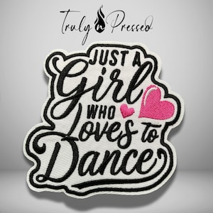 May include: An embroidered patch with a white background and black border featuring the text "JUST A Girl WHO LOVES to DANCE" in a mix of script and block lettering. Two pink embroidered hearts are positioned next to the word "LOVES".