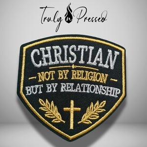 May include: A shield-shaped embroidered patch with a black background and gold border. It features the white text "CHRISTIAN" above the gold text "NOT BY RELIGION" and "BUT BY RELATIONSHIP," with a gold cross and two laurel branches below.