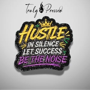 May include: A black glittery embroidered patch featuring a gold crown icon and the text HUSTLE IN SILENCE LET SUCCESS BE THE NOISE. The word HUSTLE is in gold, IN SILENCE LET SUCCESS is in white, and BE THE NOISE is in purple.