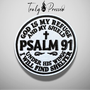 May include: A circular embroidered patch with a white background and black border. The text reads: GOD IS MY REFUGE AND MY SHIELD, PSALM 91, UNDER HIS WINGS I WILL FIND SHELTER. A small black cross is centered above the text PSALM 91.