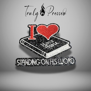 May include: An embroidered patch featuring a red heart, a black book with the text Holy Bible in white, and a black banner with the white text STANDING ON HIS WORD. The design includes a large red letter I above the book, all with black borders.