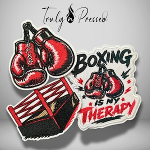 May include: Three embroidered patches featuring boxing themes. One patch shows a pair of red boxing gloves, another depicts a black and red boxing ring, and the third is a white patch with red boxing gloves and the text "BOXING IS MY THERAPY."