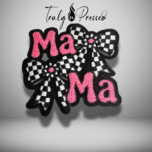 May include: Embroidered patch with the word "Mama" in pink, accented by two black and white checkered bows. The patch has a black border and the text "Truly Pressed" in the upper right corner.