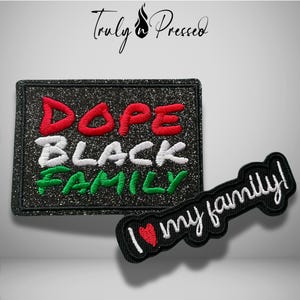 May include: A rectangular black glitter patch with embroidered text reading DOPE in red, BLACK in white, and FAMILY in green. Beside it is a smaller black patch with white embroidered text reading I (with a red heart) my family!