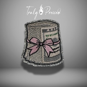 May include: Embroidered patch featuring a roll of US $100 bills tied with a pink bow. The patch has a silver glitter border and the text "Truly n Pressed" in script at the top.