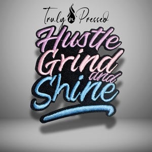 May include: Embroidered patch with the words "Hustle, Grind, and Shine" in a cursive font. The patch has a black background with the words in pink, blue, and purple. The patch also has the words "Truly Pressed" in a cursive font.
