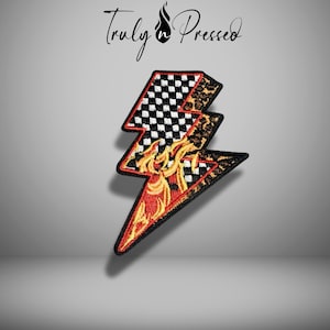 May include: Embroidered patch in the shape of a lightning bolt. The top section features a black and white checkered pattern, while the middle section has a leopard print design. The bottom section displays flames in red and yellow. The text "Truly Pressed" is at the top.