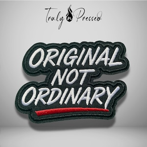 May include: A black embroidered patch featuring the white text "ORIGINAL NOT ORDINARY" in a bold, stylized font. The patch has a thick black border and a single horizontal red line underneath the word "ORDINARY" on a black background.