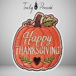 May include: An embroidered patch shaped like an orange pumpkin with a brown stem and green leaves. The text "Happy THANKSGIVING" is stitched in light tan thread across the center, with a small brown heart icon positioned below the text.