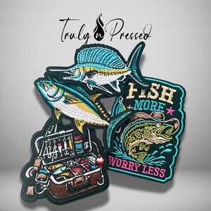 May include: Three embroidered patches featuring fishing themes. One shows a blue marlin, another a yellowfin tuna, and the third a tackle box. A rectangular patch depicts a bass wearing a hat with the text FISH MORE WORRY LESS in pink.