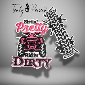 May include: Embroidered patches with the text "Sittin' Pretty Ridin' Dirty" and a pink ATV design. A black and white tire track is also included. The patches are outlined in white.