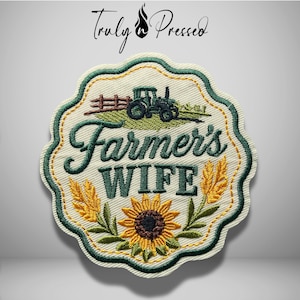 May include: A scalloped-edge embroidered patch on a cream background featuring a dark green tractor, yellow wheat stalks, and a sunflower. The text "Farmer's WIFE" is embroidered in dark green script and block letters. The border is dark green.