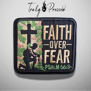 May include: A square embroidered patch with a black border. The left side features a camouflage pattern with a black silhouette of a person kneeling before a cross. The right side displays the tan text FAITH OVER FEAR and PSALM 56:3.