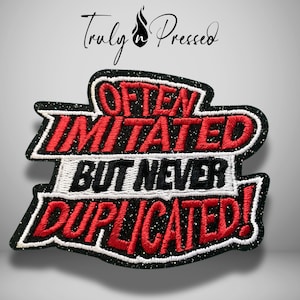 May include: A black, red, and white embroidered patch featuring the text "OFTEN IMITATED BUT NEVER DUPLICATED!" in a bold, layered font style. The patch has a glittery black background with white borders and red lettering for emphasis.