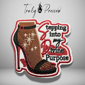 May include: An embroidered patch featuring a brown high-heeled sandal with black straps and a stiletto heel. The design includes white starburst accents and the black text Stepping into my Divine Purpose with red lettering for the word Divine.