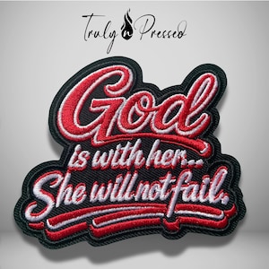 May include: A black embroidered patch featuring the red and white text "God is with her... She will not fail." The design includes a stylized red underline and a black border. Above the patch, the text "Truly Pressed" is printed in black.