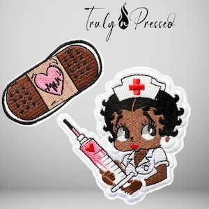 May include: Two embroidered patches featuring a brown adhesive bandage with a pink heart and a cartoon character dressed as a nurse holding a pink syringe. The nurse wears a white cap with a red cross. The text Truly Pressed is visible above.