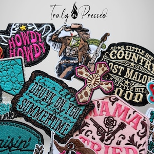 May include: A collection of embroidered patches featuring various designs including a cowgirl with a guitar, a leopard print cross, and text-based patches with phrases like Howdy Howdy, Drunk on You and Summertime, and Mama Tried in pink, teal, and black.
