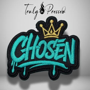 May include: An embroidered patch featuring the word CHOSEN in bright teal thread with a dripping paint effect. Above the text is a gold embroidered crown. The entire design is outlined in black thread against a black fabric background.